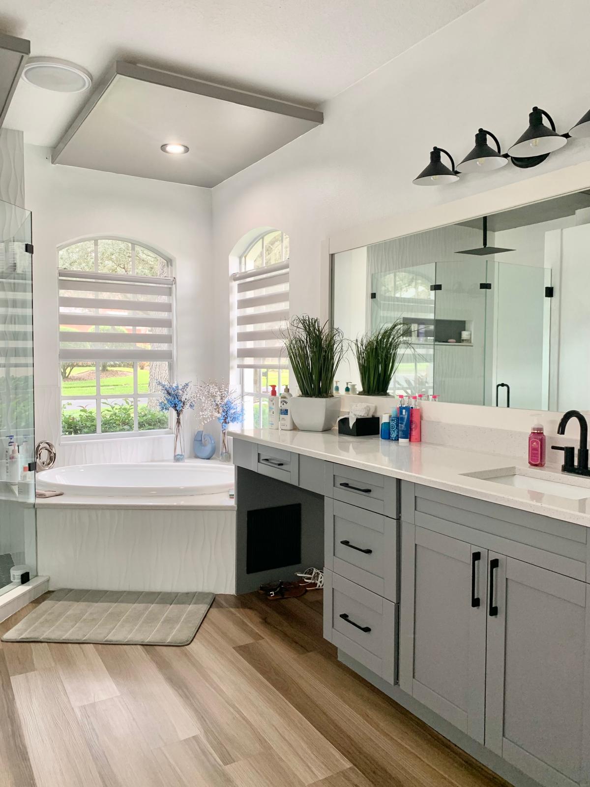 Bright, spotless bathroom with soaking tub and gray vanity